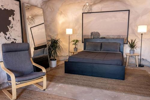 ein Schlafzimmer mit einem Bett und einem Stuhl in der Unterkunft Charming Cave near Incredible Outdoor Activities for an Amazing Adventure in Moab, Utah in Allen Memorial Hospital Heliport