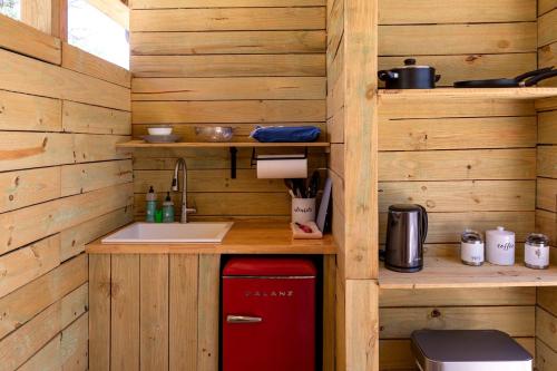 Hammetts CrossingにあるChrissie Ger in Dripping Springs, TXの木造キャビン内のキッチン(赤い冷蔵庫付)