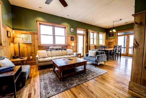 un salon avec un canapé et une table dans l'établissement Modern and Cozy Cabin Rental Between Mountains and River in Northern Georgia, à Mineral Bluff