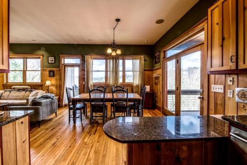 une cuisine et un salon avec une table et des chaises dans l'établissement Modern and Cozy Cabin Rental Between Mountains and River in Northern Georgia, à Mineral Bluff