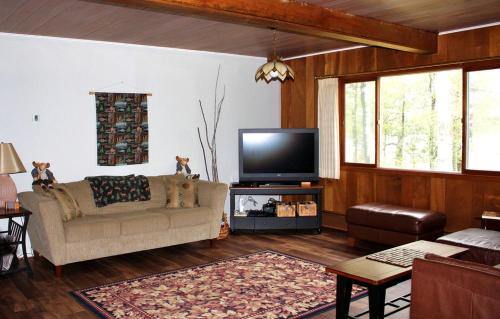 a living room with a couch and a flat screen tv at Lakefront Cottage Rental with Game Room near Ruth Lake, Minnesota in Emily