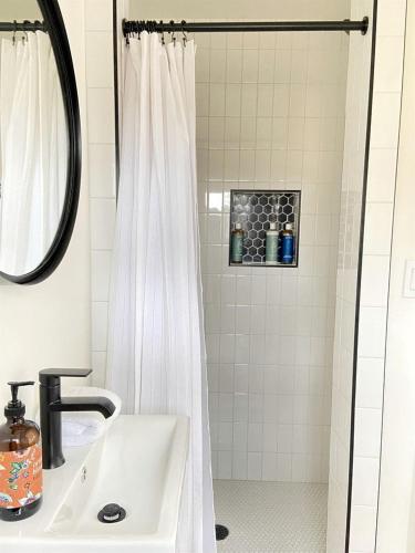 a bathroom with a white shower curtain and a sink at Efficiency-Style Cabin with Spa Lovely for a Couples Escape in Hunt, Texas in Hunt