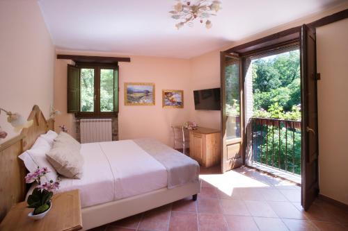 ein Schlafzimmer mit einem Bett und einem Balkon in der Unterkunft Historic Boutique Hotel Maccarunera in Campagna