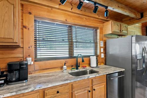 a kitchen with a stainless steel refrigerator and a sink at Stunning Cabin with Hot-tub, Fire Pit and Games in Stanton, Kentucky in Stanton