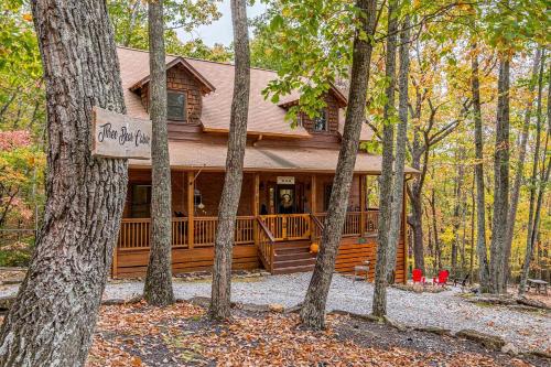 a log cabin in the woods with trees at Relaxing Cabin with Screened Porch in Sautee Nacoochee, Georgia in Sautee Nacoochee