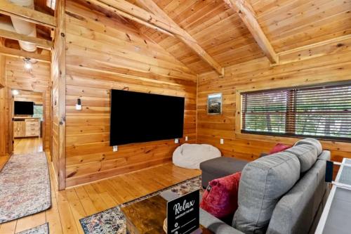a living room with a flat screen tv in a log cabin at Stunning Cabin with Hot-tub, Fire Pit and Games in Stanton, Kentucky in Stanton