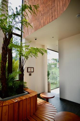 a living room with a large window and a plant at Là Yên Villa - Đà Lạt in Ấp Ða Lợi