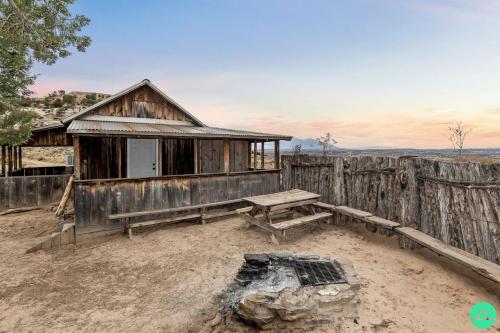 a wooden cabin with a bench and a picnic table at Rustic Secluded Cabin with Stunning Sights in Monticello, Utah in Monticello