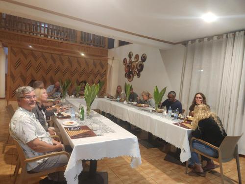 a group of people sitting at a long table at Hotel ikoro in Nyakabande