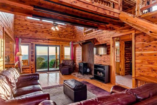 a living room with leather furniture in a log cabin at Incredible Pet-Friendly Cabin Located on Top of a Magnificent Mountain in Compton, AR in Compton