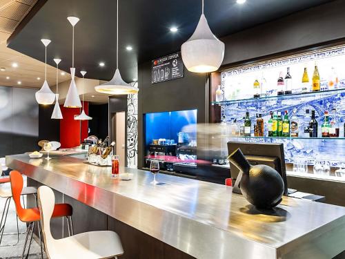 a bar in a restaurant with a counter and chairs at Hotel ibis Porto Gaia in Vila Nova de Gaia