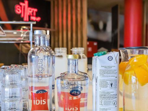 a table with two bottles of water and glasses at Hotel ibis Porto Gaia in Vila Nova de Gaia