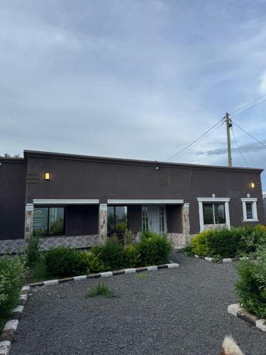 a black building with a driveway in front of it at Villa maasai in Kimana