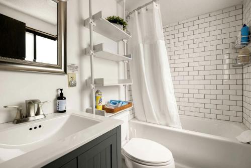 a bathroom with a toilet and a tub and a sink at Enchanting A-Frame Cabin Retreat near Berkeley Springs and Mountain Views in West Virginia in Baxter