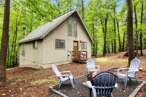 a group of chairs sitting in front of a cabin at Enchanting A-Frame Cabin Retreat near Berkeley Springs and Mountain Views in West Virginia in Baxter