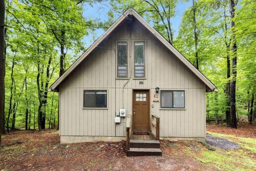 a small house in the middle of a forest at Enchanting A-Frame Cabin Retreat near Berkeley Springs and Mountain Views in West Virginia in Baxter