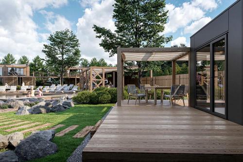 a backyard with a wooden deck with a table and chairs at Magical Retreat with a Pool Ideal for Luxury Camping, Austria in Unterlibitsch