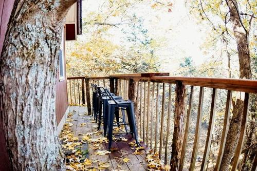 a deck with benches and a tree on a porch at Enchanting Tree House with a Slide on 200 Acres for a Family Adventure in Germantown, Kentucky in Germantown
