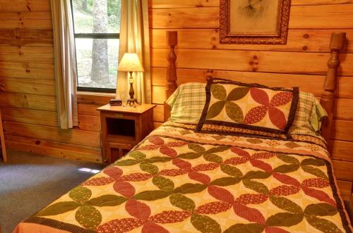 a bedroom with a bed in a log cabin at Lovely Rustic Cabin Secluded in the Woods near Maggie Valley, North Carolina in Cherokee