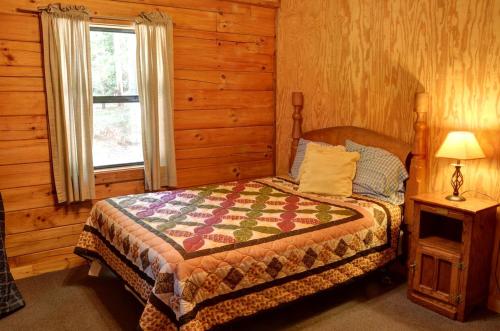 a bedroom with a bed and a window at Lovely Rustic Cabin Secluded in the Woods near Maggie Valley, North Carolina in Cherokee