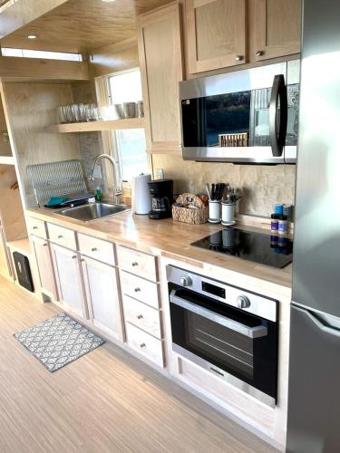 una cocina con fregadero y estufa horno superior en Secluded Tiny House Oasis in Grand Junction Perfect for Experiencing Nature in Comfort, en Grand Junction