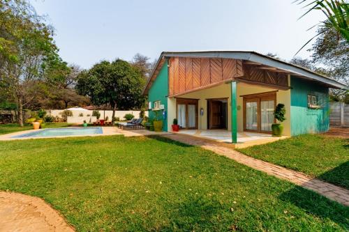 a green house with a pool in front of it at Kasongo Lodge in Victoria Falls