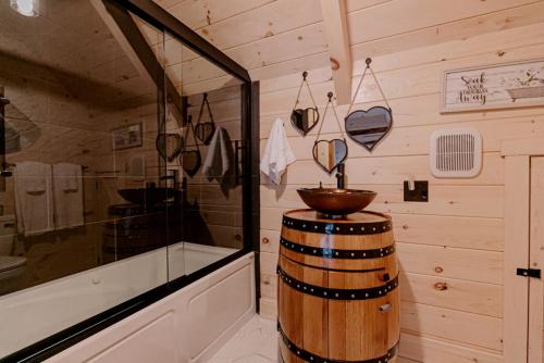 ein Badezimmer mit Fass und Dusche in der Unterkunft Secluded Wooden Cabin with Fire Pit, Barbecue and Hot-tub in Campbellsville, Kentucky in Campbellsville