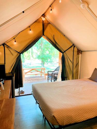 a bedroom with a tent with a bed in it at 24 Son's Secluded Safari Tent in Kingsbury, TX in Staples