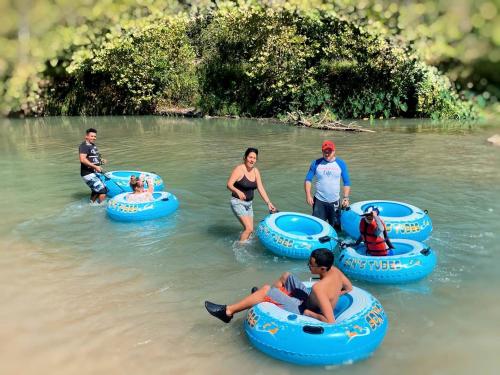 a group of people in inflatable tubes in the water at 24 Son's Secluded Safari Tent in Kingsbury, TX in Staples