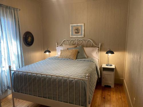 une chambre avec un lit et deux lampes et une fenêtre dans l'établissement Elevate Your Holidays: Glamping at Cypress Creek Cottage, Texas' Hidden Gem, à Wimberley