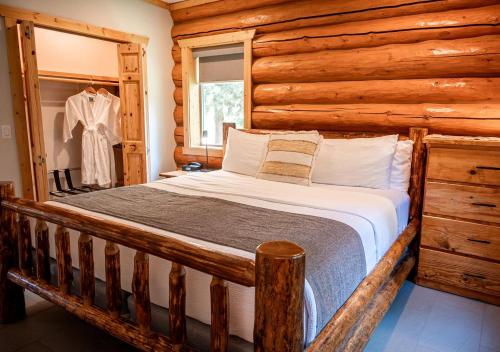 ein Schlafzimmer mit einem Bett in einer Blockhütte in der Unterkunft Spacious Pet-Friendly Log Cabin with King Bed & Full Kitchen | Bonners Ferry, Idaho Retreat in Bonners Ferry