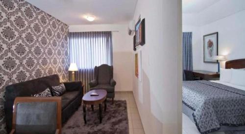 una habitación de hotel con un sofá y una cama en Terranova Suites, en Santa Cruz de la Sierra