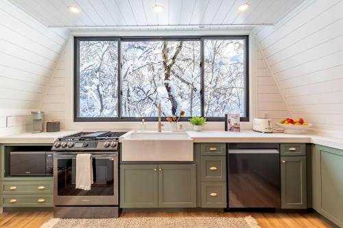 a kitchen with a sink and a large window at Lovely Secluded A-frame with Hot-tub in Sundance, Utah in Sundance