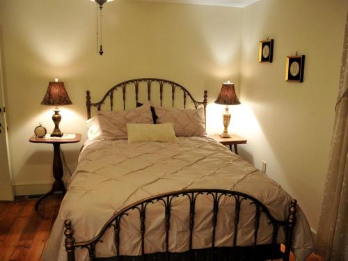 ein Schlafzimmer mit einem Bett mit zwei Lampen auf zwei Tischen in der Unterkunft Spacious Cottage Rental with Creek Views near Harrisburg and Hershey, Pennsylvania in Highspire