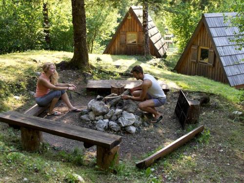 un hombre y una mujer sentados alrededor de una fogata en Lovely Retreat for Adventurous Getaways in Slovenia, en Soča