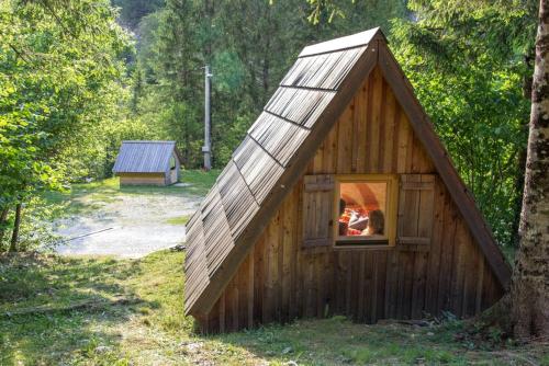 Una pequeña casa de juegos de madera con ventana. en Lovely Retreat for Adventurous Getaways in Slovenia, en Soča