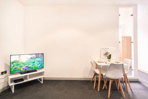 a dining room with a tv and a table with chairs at Fabulous Central Blackburn 1 Bed Apartment in Blackburn