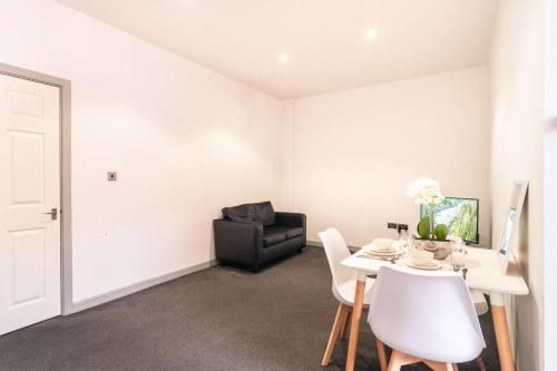 a living room with a table and a chair at Fabulous Central Blackburn 1 Bed Apartment in Blackburn