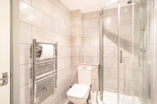 a bathroom with a toilet and a shower at Fabulous Central Blackburn 1 Bed Apartment in Blackburn