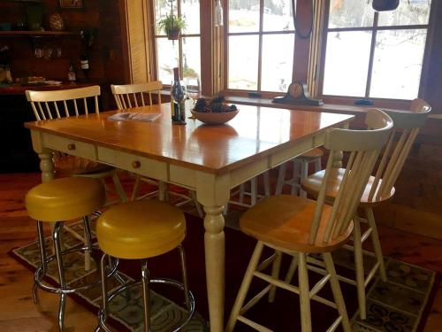 Una mesa de madera con cuatro sillas alrededor. en Private Rustic Cabin with Ski-In and Ski-Out Access in Jackson, New Hampshire, en Jackson