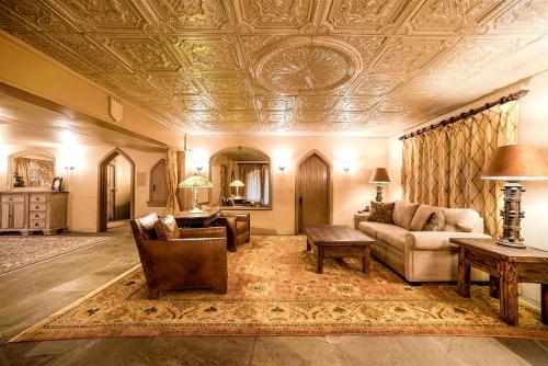 un soggiorno con soffitto a cassettoni e divano di Regal Castle Suite for a Luxury Getaway to Lake George in Upstate New York a Bolton Landing
