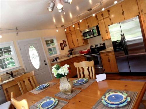 a kitchen with a wooden table and a refrigerator at Cozy Vacation Cottage Rental near Lassen Volcanic National Park, Northern California in Shingletown