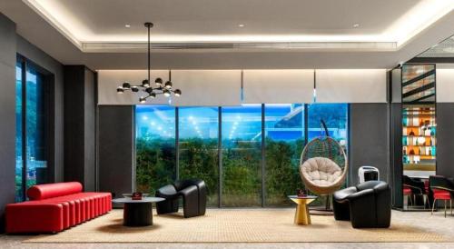 a living room with a red couch and chairs at ibis Dongguan Dongcheng in Dongguan