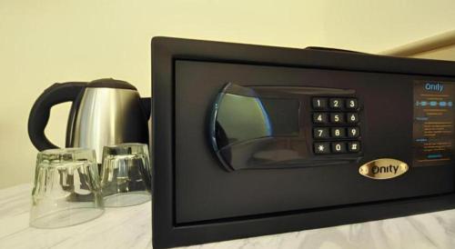 a microwave on a table with two glasses at King's Hotel in Hong Kong