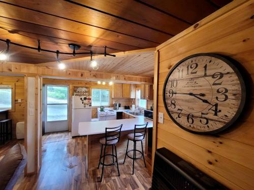 a large clock on the wall of a kitchen at Cozy Lakeside Log Cabin with Kayaks & Arcade Access near Trails in Bitely, Michigan in Bitely