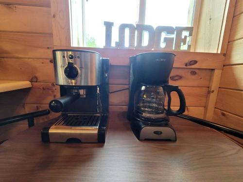 a coffee maker and a coffee pot on a table at Cozy Lakeside Log Cabin with Kayaks & Arcade Access near Trails in Bitely, Michigan in Bitely