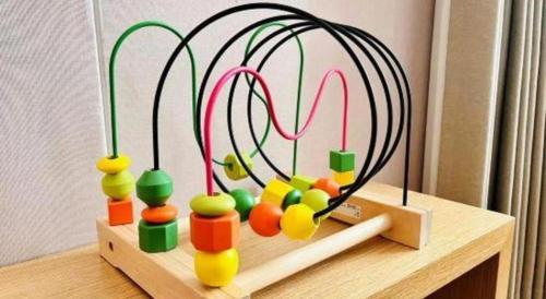 a wooden table with a toy with balls and wires at New Beacon Sunyee SPA Hotel in Wuhan