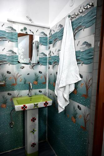 a bathroom with a green sink and a towel at maa kalishila home stay in Ukhimath
