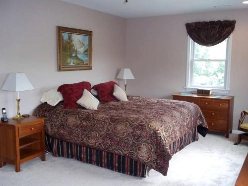 a bedroom with a bed and two night stands and a window at Charming Vacation Rental overlooking New River in the Blue Ridge Mountains of Virginia in Independence