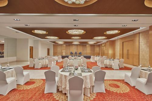 a banquet hall with white tables and chairs at Four Points by Sheraton Hotel and Serviced Apartments Pune in Pune